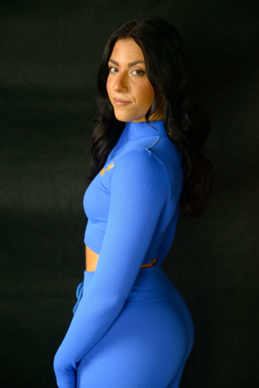 Woman wearing a  blue risen outfit 2pc set with a black background